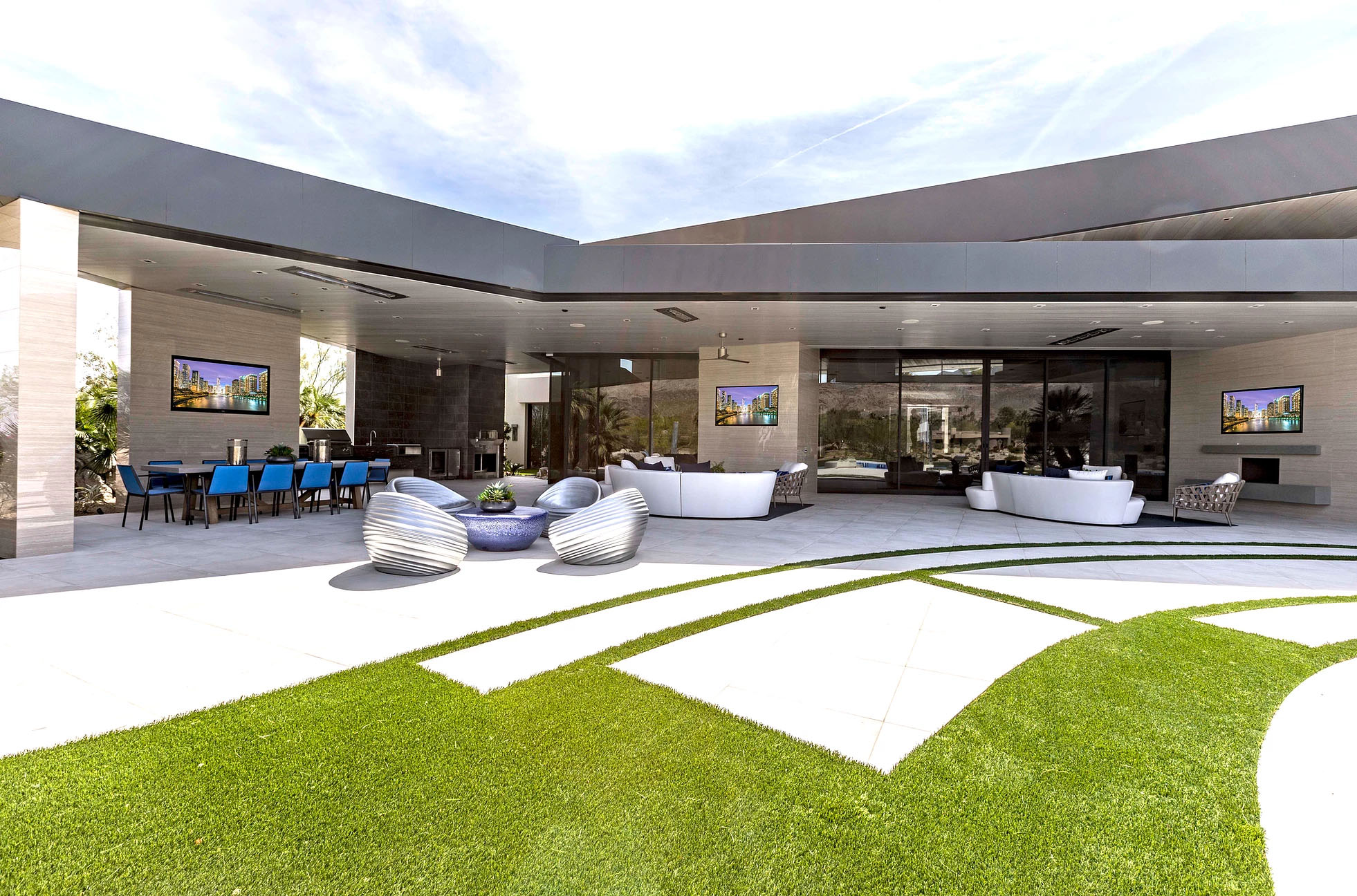 An indoor-outdoor space in California. The house has a large portion of glass wall that can be pushed away to create an open space, with central AV systems installed by AVIR.